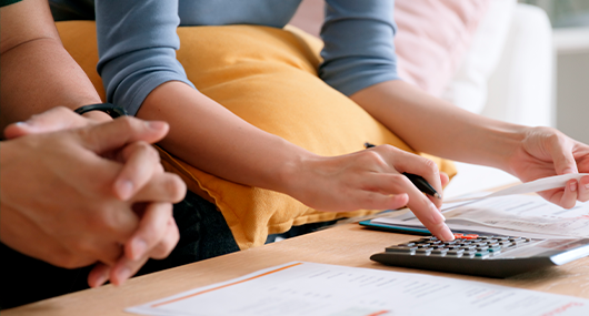 Couples doing finances with a calculator.