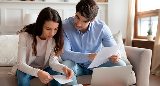 Couple checking receives papers and other documents for finance.