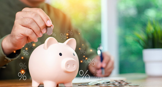 A man adds coins to a piggy bank, representing the importance of saving for retirement through various plans in Texas.