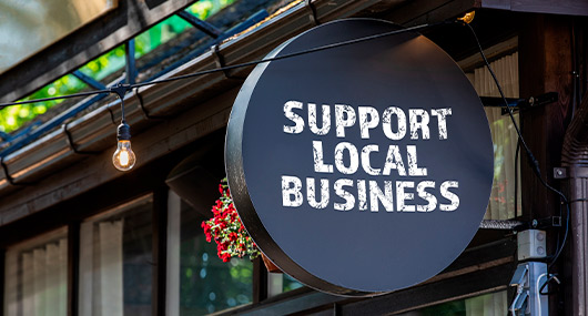Local business support sign featured in a Black Friday shopping context for McAllen shoppers.