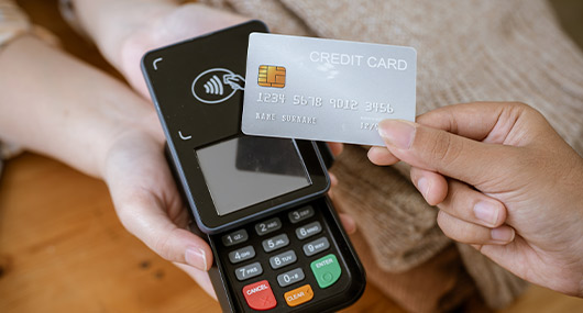 Individual with a credit card and mobile phone, representing savvy shopping strategies for Black Friday in McAllen.