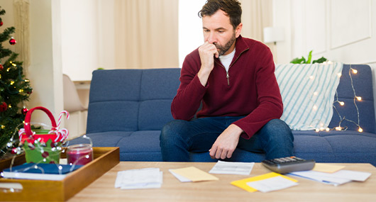 A man relaxes on a sofa adorned with Christmas decorations, embodying the holiday spirit in a South Texas home.